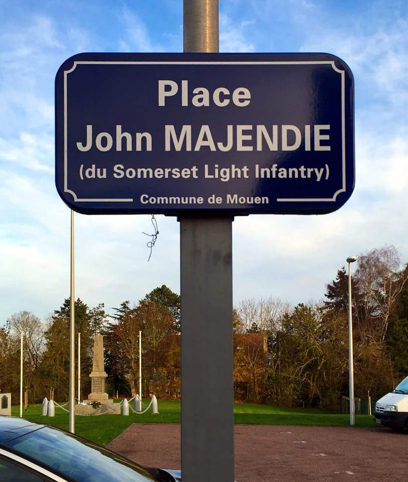 Le panneau de la place John-Majendie à Mouen. Vue de la commune ; la bibliothèque Charles-Thomine-Desmazures n’est pas représentée.